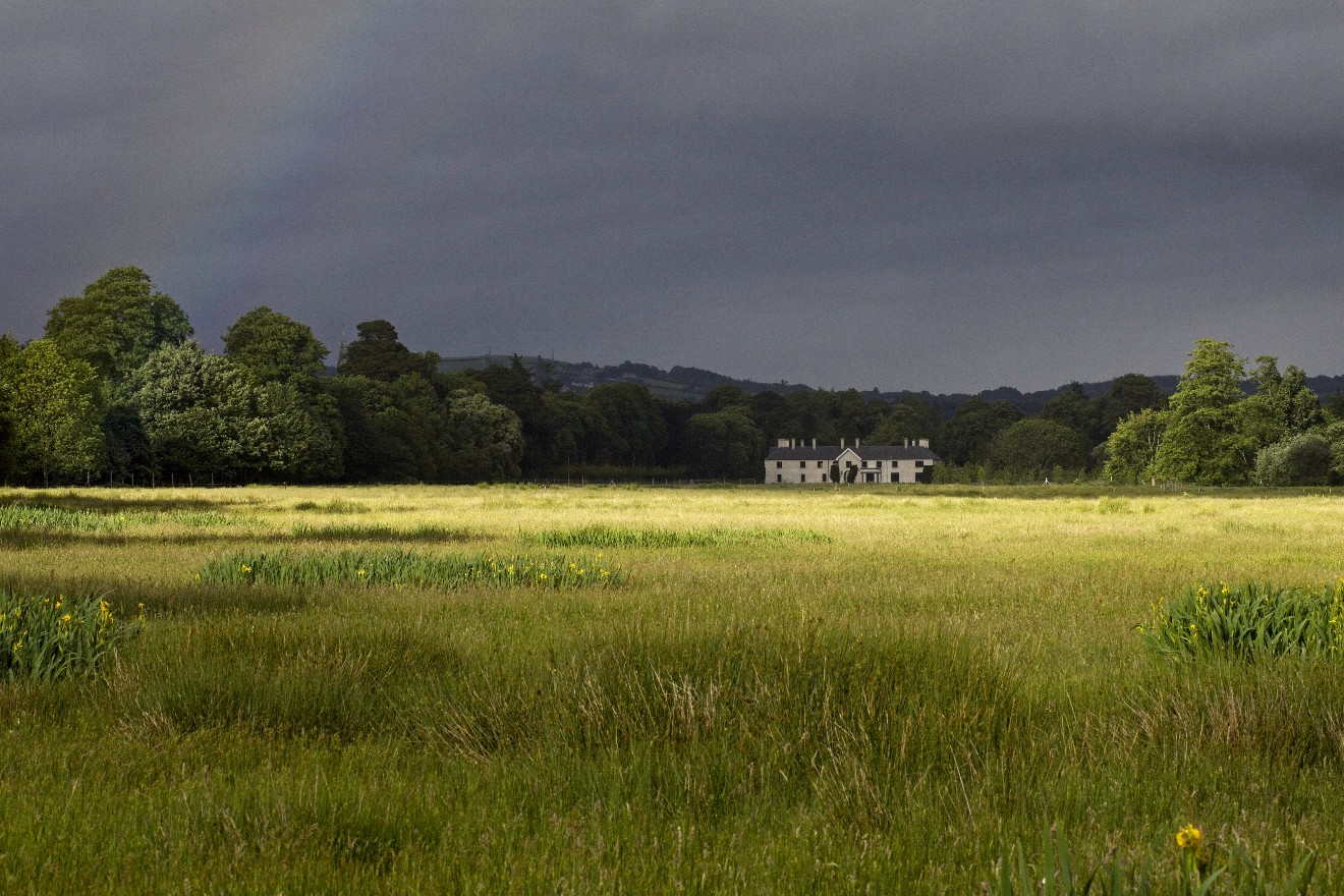Ein Haus im Killarney Nationalpark (Irland) mit einem Regenbogen.