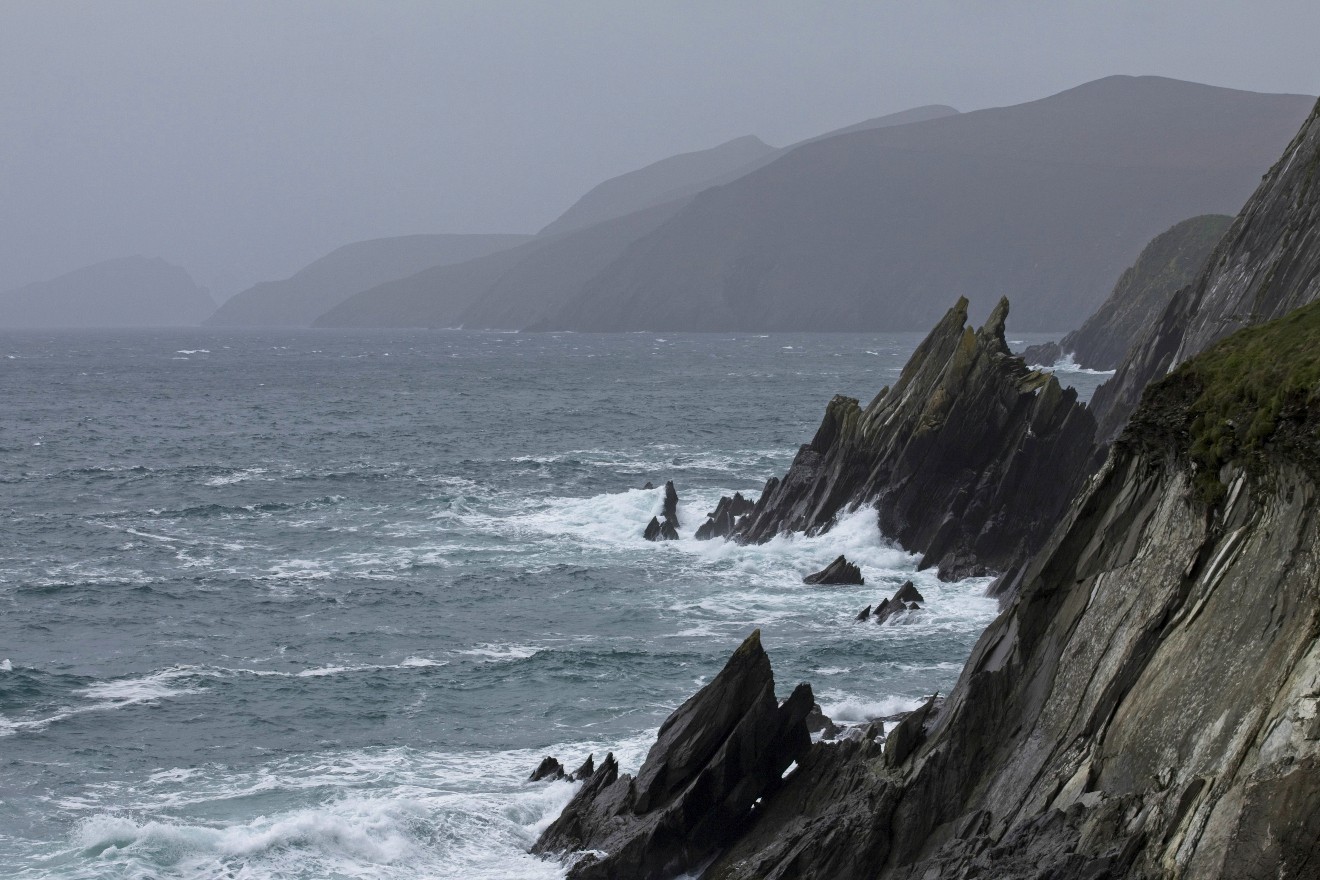 Blick auf Steilhang mit Inseln im Hintergrund am Ring of Kerry in Irland.