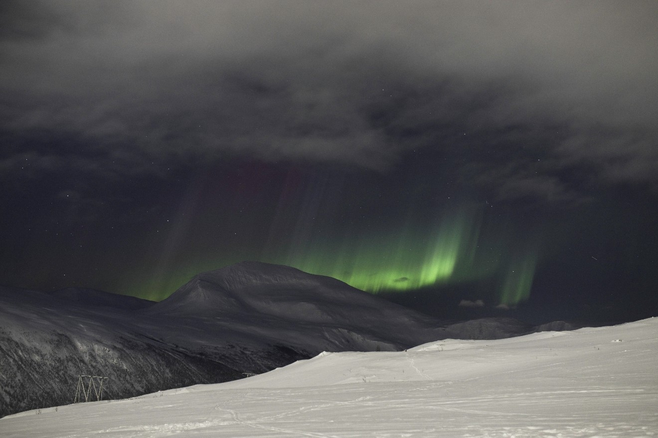 Nordlichtstreifen hinter Gebirge